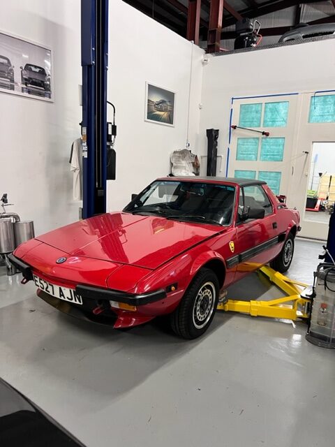 Classic red European car on a lift at Bekardi Garage Houston